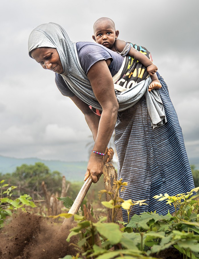 Aissatou con su hĳo más pequeño en la huerta familiar. · Foto: Franca Levin