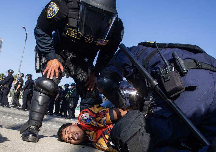 Oficiales de la Patrulla de Caminos de California arrestan a un manifestante, el 10 de junio, en Los Ángeles. · Foto: Apu Gomez, AFP