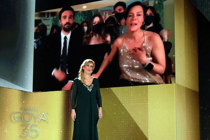 Los productores Alex Lafuente (i) y Valerie Delpierre (en pantalla) reciben el premio a la Mejor Película por "Las Niñas", entregado por la enfermera Ana María Ruíz, el 6 de marzo, en el escenario de la 35a gala de los Premios Goya celebrada en el teatro Soho de Málaga. Foto: Miguel A. Córdoba, AFP