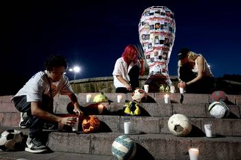 Estudiantes de la Universidad Jesuita de Guadalajara con una réplica del trofeo de la Copa Mundial decorada con fotografías de personas desaparecidas, el 21 de noviembre, en Guadalajara. · Foto: Ulises Ruiz, AFP
