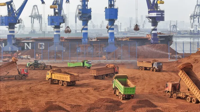 Descarga de minerales que se trasladan a la planta de aluminio electrolítico en el puerto de Yantai, China, el 25 de marzo. · Foto: AFP