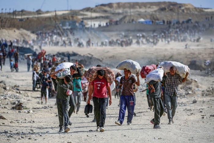 Palestinos regresan de un punto de distribución de alimentos, el 5 de octubre, cerca del corredor de Netsarim en el centro de la Franja de Gaza. · Foto: Eyad Baba, AFP