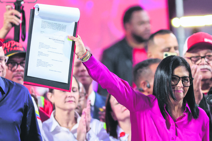 La presidenta interina de Venezuela, Delcy Rodríguez, sostiene una copia de la Reforma a la Ley Orgánica de Hidrocarburos, el 29 de enero en el Palacio Presidencial de Miraflores en Caracas. · Foto: Pedro Mattey, AFP