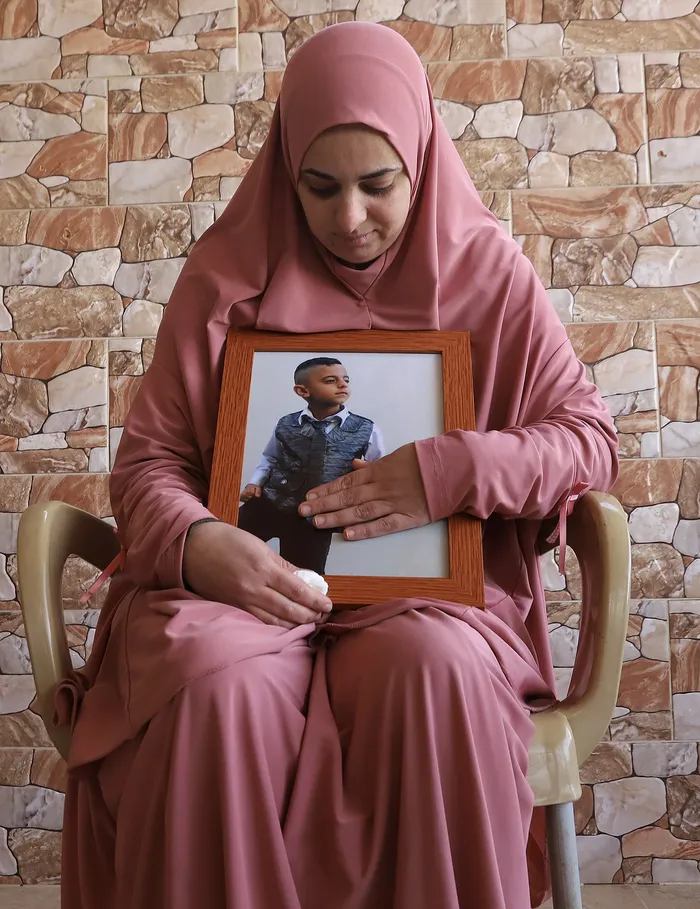 Fidaa Basharat sostiene una fotografía de su hĳo Rida Basharat, quien murió el 8 de enero de 2025 cerca de su casa en un ataque aéreo israelí junto con dos primos: Hamzah y Adam. · Foto: Quique Kierszenbaum