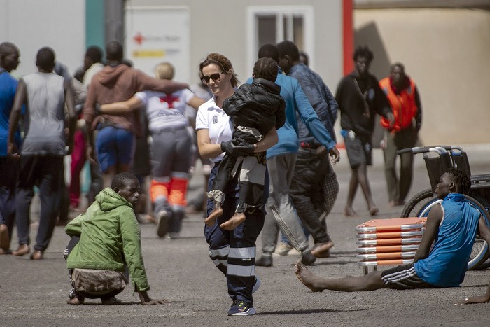 Integrantes de los servicios de emergencia españoles atienden a un grupo de personas migrantes que llegaron al puerto de Restinga en las Islas Canarias, provenientes de Senegal. · Foto: Antonio Sempere, AFP