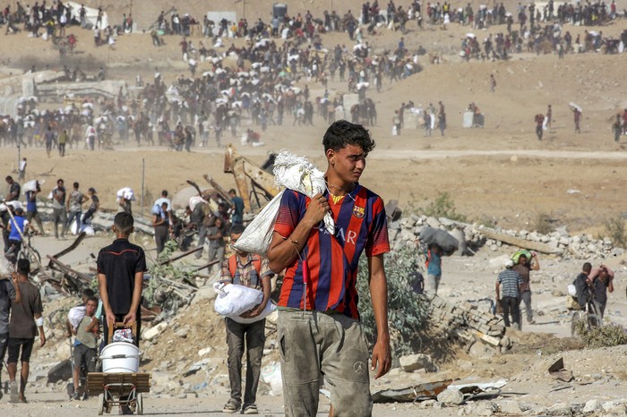 Personas con ayuda humanitaria recibida en un centro de distribución en el corredor Netzarim, en el centro de la Franja de Gaza. · Foto: Eyad Baba, AFP