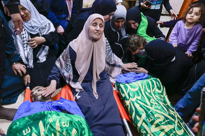 Una mujer junto a los cuerpos de sus dos hijos muertos en un ataque israelí en el campo de refugiados de Nur Shams, en Cisjordania, el 21 de abril. · Foto: Jaafar Ashtiyeh, AFP