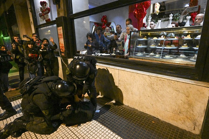 Policías detienen a un manifestante frente a un restaurante en Buenos Aires, el 12 de junio. · Foto: Luis Robayo, AFP