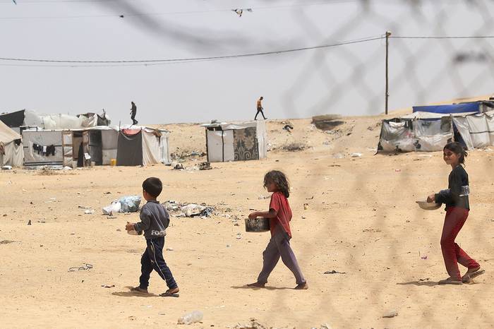 Niños palestinos desplazados luego de recibir comida en Rafah, en el sur de la Franja de Gaza, el 19 de mayo de 2024. · Foto: S/d de autor, AFP