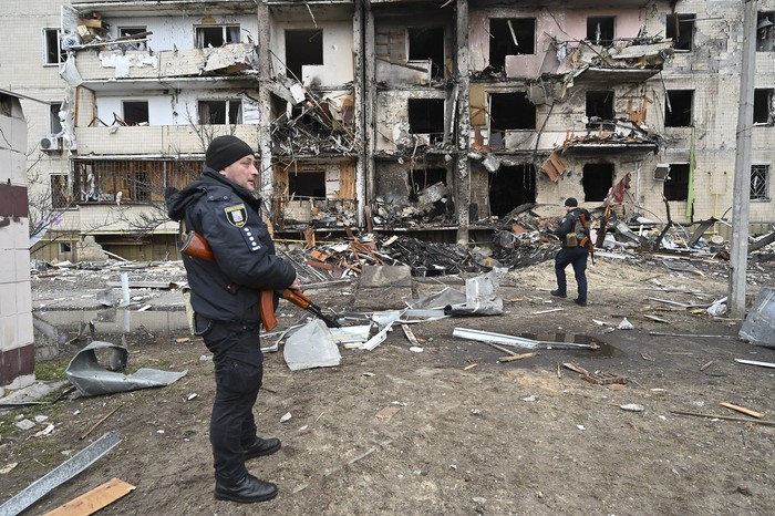 Policías frente a un edificio dañado por un proyectil ruso en un barrio de Kiev, capital de Ucrania. · Foto: Genya Savilov, AFP 