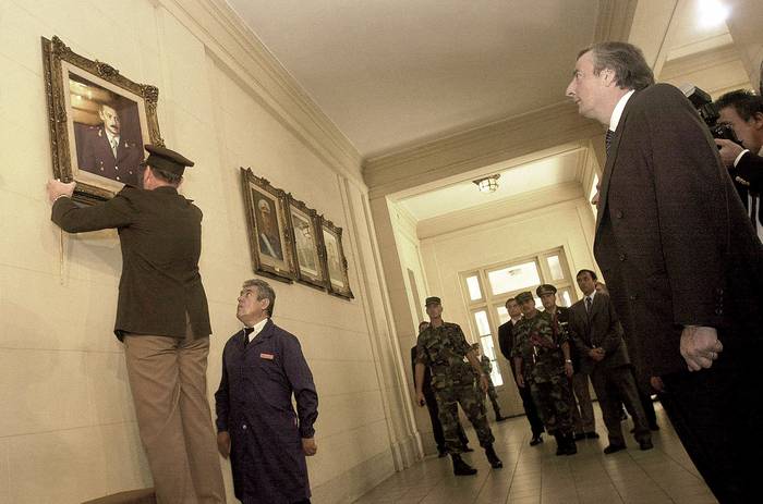 El jefe del Ejército, Roberto Bendini, y el presidente, Néstor Kirchner, al momento de quitar el retrato del dictador Jorge Rafael Videla, en el Colegio Militar de El Palomar, el 24 de marzo de 2004. · Foto: María Eugenia Cerutti