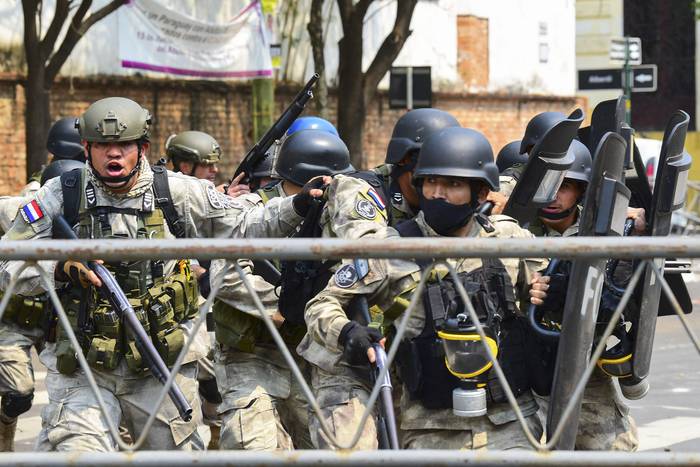Policías antidisturbios reprimen una movilización contra la ley que aumenta las penas para quienes ocupen tierras en Paraguay, el 30 de setiembre. · Foto: Norberto Duarte, Afp