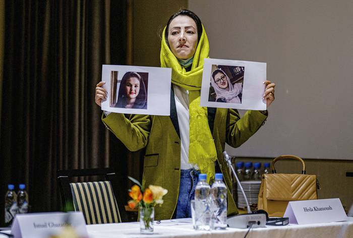 Heda Khamoush, delegada de la sociedad civil afgana con los retratos de dos activistas de los derechos humanos recientemente detenidas en Afganistan, durante la reunión con representantes del gobierno Talibán y autoridades noruegas en Oslo, el lunes 24. · Foto:  Stian Lysberg Solum / NTB Scanpix / AFP