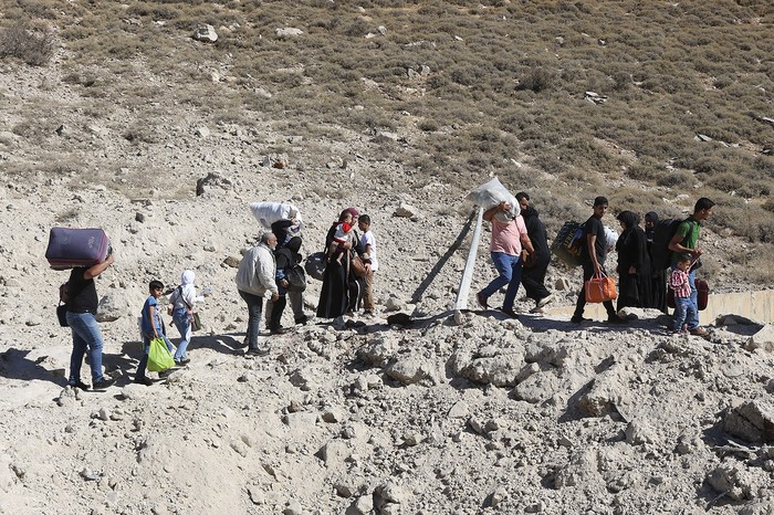 Habitantes de Líbano en una carretera destruida por bombardeos israelíes, en Masnaa, próximo a la frontera con Siria. · Foto: Hassan Jarrah, AFP