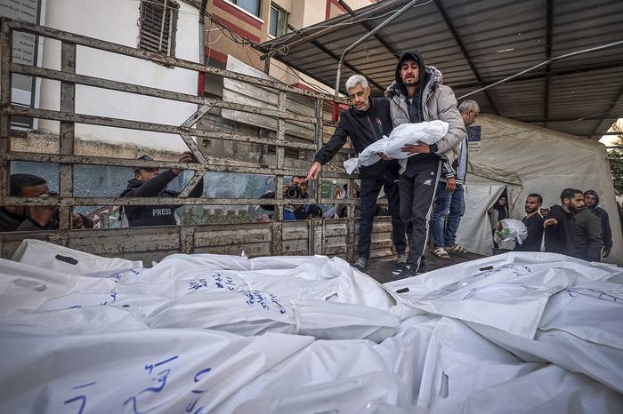 Cuerpos de personas muertas durante bombardeos israelíes en el sur de la Franja de Gaza, son depositados en un camión frente al hospital Al-Najar. · Foto: Stringer, AFP