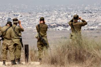 Soldados del ejército israelí observan los edificios destruidos en la Franja de Gaza, el 13 de agosto, desde la frontera con el territorio palestino. · Foto: Jack Guez, AFP