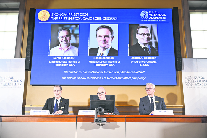 Hans Ellegren (c), secretario permanente de la Academia de Ciencias, Jakob Svensson (i), y Jan Teorell, de la Asamblea Nobel, durante el anuncio del Premio Sveriges Riksbank de Ciencias Económicas 2024 para Daron Acemoglu, Simon Johnson y James Robinson, el 14 de octubre, en Estocolmo, Suecia. · Foto: Christine Olsson, TT News, AFP