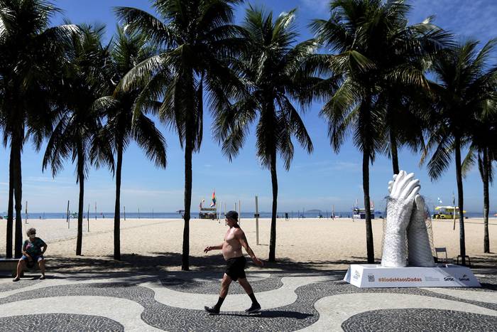 Diez esculturas representan el posible retorno al contacto físico tras el avance de la vacunación, el 4 de febrero, en la playa de Copacabana, en Río de Janeiro. · Foto:  Antonio Lacerda, Efe