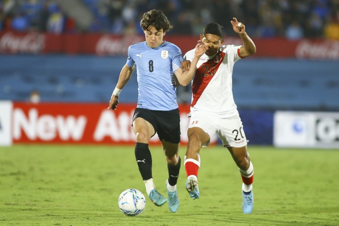 Facundo Pellistri, de Uruguay, y Edison Flores, de Perú, el 24 de marzo de 2022, en el estadio Centenario. · Foto: Ernesto Ryan
