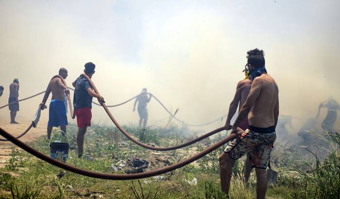 Vecinos y bomberos combaten el incendio, el 8 de enero, en Pinar Norte. · Foto: Mara Quintero