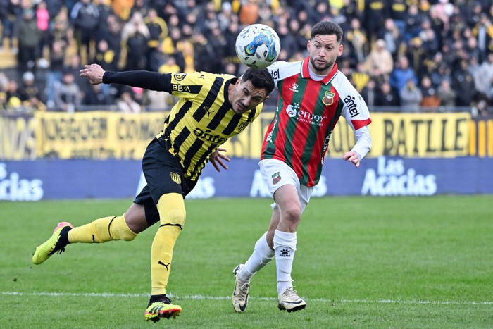 Eduardo Darias, de Peñarol, y Nicolás Queiroz, de Deportivo Maldonado, en el estadio Campeón del Siglo (archivo, julio de 2024). · Foto: Guillermo Legaria