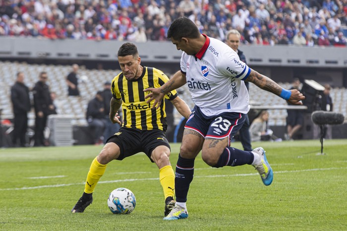 Javier Cabrera, de Peñarol y Diego Polenta, de Nacional en el estadio Centenario (archivo, agosto de 2024). · Foto: Rodrigo Viera Amaral