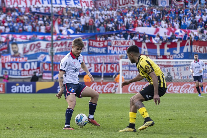 Jeremía Recoba, de Nacional, y Maximiliano Olivera, de Peñarol, durante un clásico en el estadio Centenario (archivo, agosto de 2024). · Foto: Rodrigo Viera Amaral