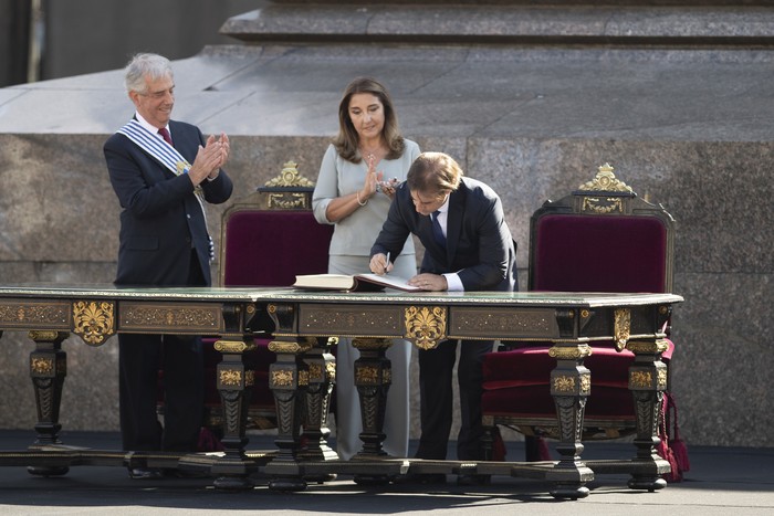 El presidente entrante Luis Lacalle Pou firma el acta del traspaso de mando ante escribana pública, durante la ceremonia de traspaso del mando presidencial, en la plaza Independencia (archivo, marzo de 2020). · Foto: Sandro Pereyra