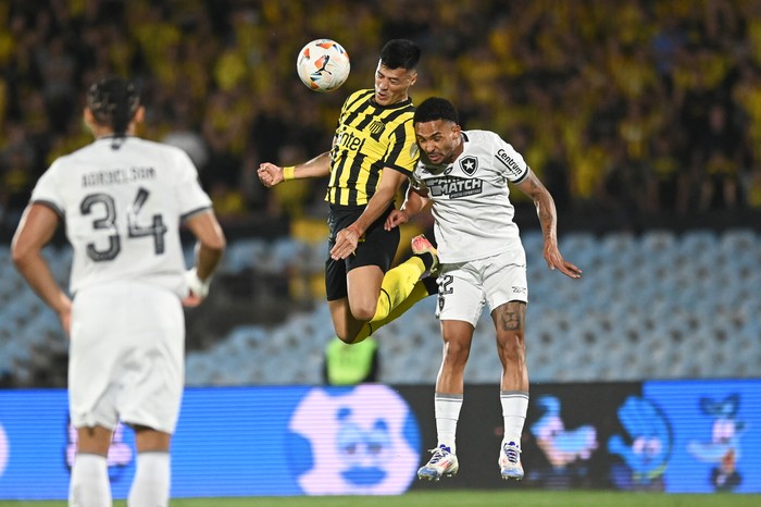 Leonardo Sequeira, de Peñarol, y Vitinho, de Botafogo, durante el partido de Copa Libertadores en el estadio Centenario. · Foto: Alessandro Maradei