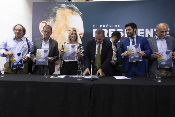 Eduardo Lust, Guido Manini Ríos, Valeria Ripoll, Álvaro Delgado, Agustín Iturralde, Andrés Ojeda y Pablo Mieres, el 4 de noviembre, en la sede de campaña del Partido Nacional. · Foto: Ernesto Ryan