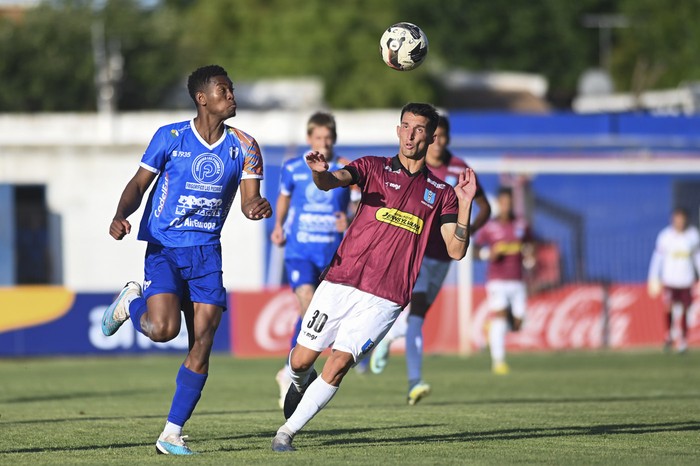 Federico Puente, de Juventud, y Brian Vargas, de Uruguay Montevideo, en el estadio Parque Artigas de  Las Piedras. · Foto: Alessandro Maradei