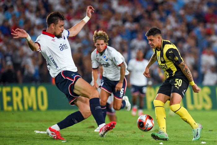 Sebastián Coates, de Nacional, y Diego García, de Peñarol, en el Gran Parque Central. · Foto: Gianni Schiaffarino