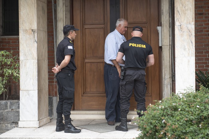 Gustavo Penadés, y los efectivos policiales que fueron a buscarlo en su domicilio, para trasladarlo a la cárcel. · Foto: Gianni Schiaffarino