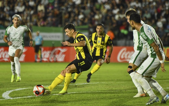 Maximiliano Silvera, de Peñarol, y Haibrany Ruiz Díaz e Yvo Calleros, de Plaza Colonia, durante el partido por la sexta fecha del Apertura, en el Campus Alberto Suppici. · Foto: Ignacio Dotti