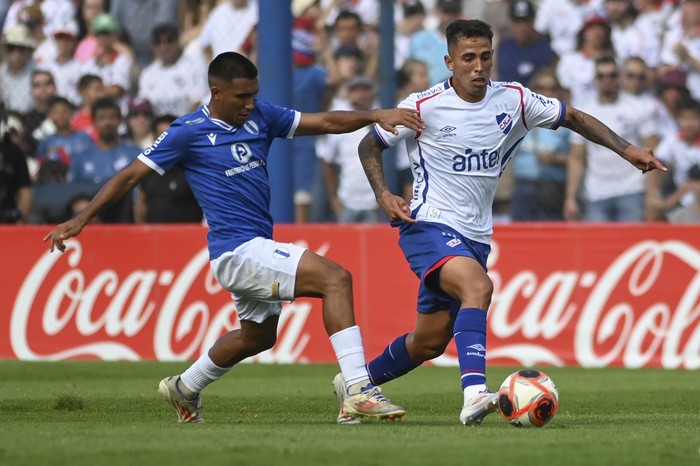 Ramiro Peralta, de Juventud, y Christian Oliva, de Nacional, en el estadio Parque Artigas de Las Piedras por la novena fecha del Torneo Apertura, el 30 de marzo. · Foto: Alessandro Maradei