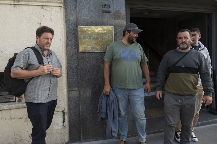 Carlos Bico, Antonio Ferreira, Nery Uria y Marcos Nieto, trabajadores de Paycueros, a la salida del Ministerio de Trabajo (archivo, abril de 2025). · Foto: Alessandro Maradei