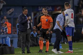 Autoridad de Conmebol con la petaca arrojada desde una tribuna, junto al árbitro Darío Herrera, el 9 de abril, en el estadio Gran Parque Central. · Foto: Rodrigo Viera Amaral