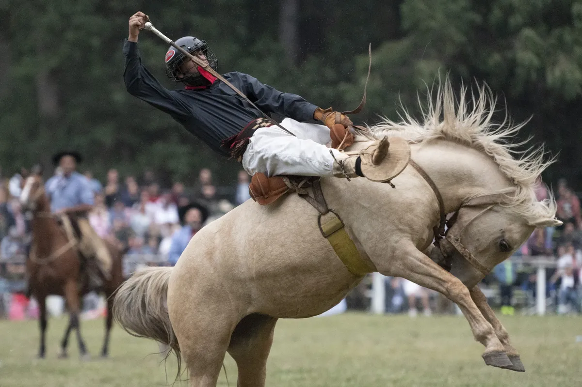 Foto de un jinete montando un caballo en una jineteada
