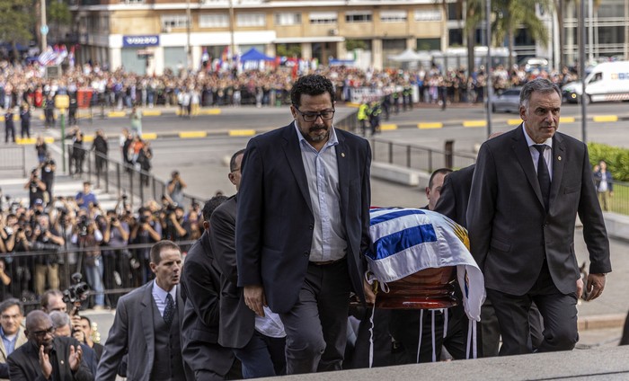 Alejandro Sánchez y Yamandú Orsi cargan el féretro en la escalinata del Palacio Legislativo. · Foto: Ernesto Ryan