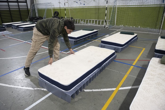 Trabajadores de SINAE arman camas en el Gimnasio de la plaza de de deportes N° 2, en Gral Flores y Amezaga, en Montevideo. · Foto: Alessandro Maradei