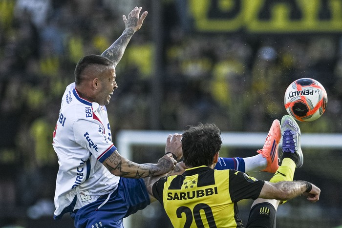 Nicolás López, de Nacional y Pedro Milans, de Peñarol, en el estadio Campeón del Siglo. · Foto: Gianni Schiaffarino