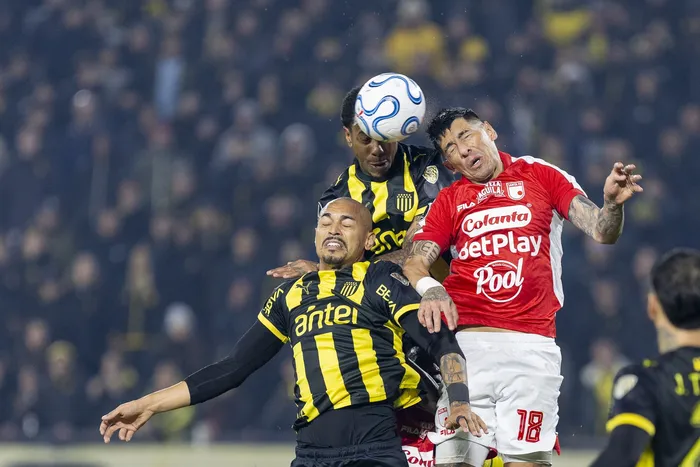 Emanuel Gularte y Abel Hernández, de Peñarol, con Emmanuel Olivera, de Independiente Santa Fe, el 27 de mayo en el Campeón del Siglo. · Foto: Rodrigo Viera Amaral