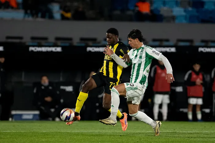 Luis Angulo, de Peñarol, y Felipe Álvarez, de Racing el 12 de julio en el estadio Centenario. · Foto: Gianni Schiaffarino