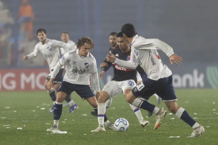 Luciano Boggio y Baltasar Barcia, de Nacional, y Gonzalo Martínez, de Tigre, el 21 de julio, en el Gran Parque Central. · Foto: Rodrigo Viera Amaral