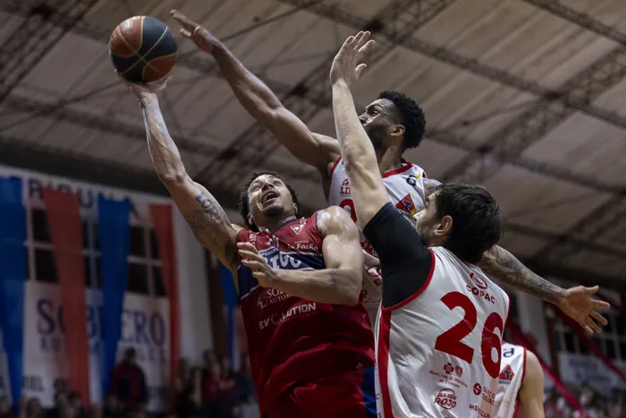 Josh Ferguson, de Sayago con Dennis Mckinney y Rodrigo Brause de Trouville, el 24 de setiembre, en la cancha de Sayago. · Foto: Rodrigo Viera Amaral