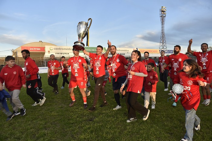 Sebastián Farías, Junior Rodríguez y John Burgardt, de Universitario de Salto, el 3 de agosto, luego de salir campeones de la 21ª Copa Nacional de Clubes, en el estadio Ernesto Dickinson, en Salto. Foto: Fernando Morán, Agencia Gamba.