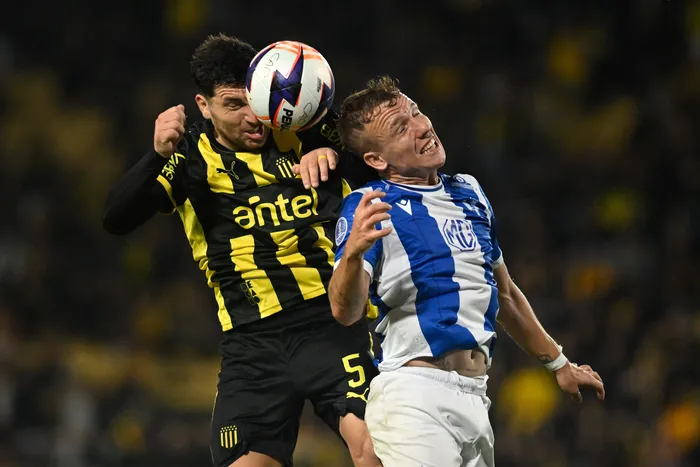 Eric Remedi, de Peñarol, y Facundo Pérez, de Juventud, durante el partido por la duodécima fecha del Torneo Apertura de la Liga AUF Uruguaya, el 20 de abril, en el Campeón del Siglo. · Foto: Guillermo Legaria, Agencia Gamba