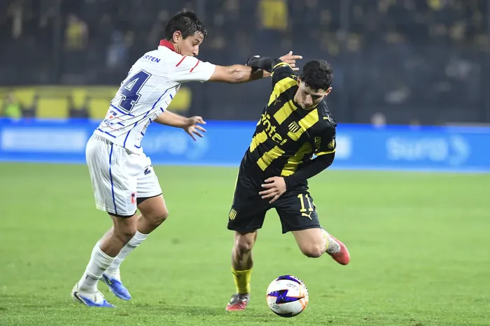 Guillermo Gandolfo, de Central Español, y Leonel Jaime, de Peñarol, por la segunda fecha del Torneo Clausura de la Liga AUF Uruguaya, el 16 de agosto, en el Campeón del Siglo. · Foto: Sandro Pereyra, Agencia Gamba