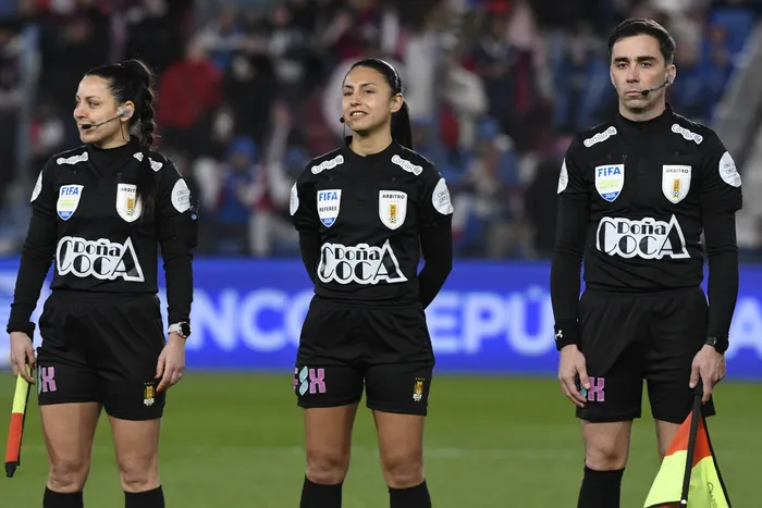 Daiana Fernández, Anahí Fernández y Horacio Ferreiro, el 23 de agosto, durante el partido Nacional vs Progreso en el estadio Gran Parque Central, en Montevideo. · Foto: Sandro Pereyra, Agencia Gamba