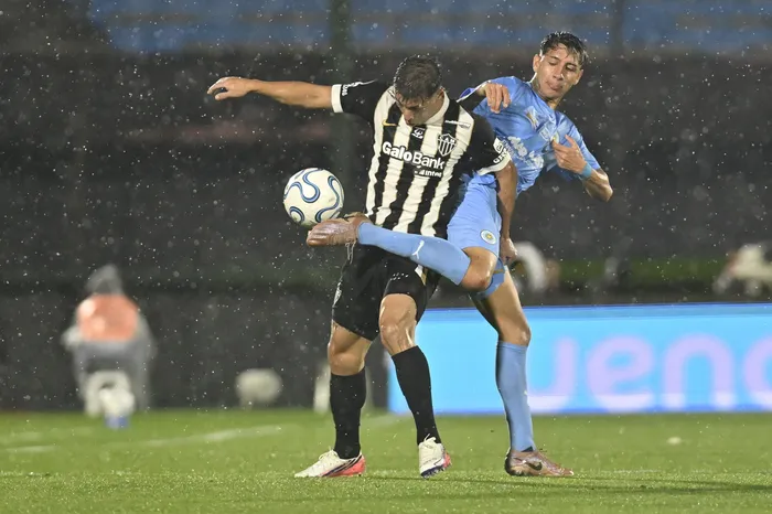 Alan Franco, de Atlético Mineiro, y Diogo Guzmán, de Montevideo City Torque, el 21 de octubre, en el estadio Centenario. · Foto: Guillermo Legaria, Agencia Gamba